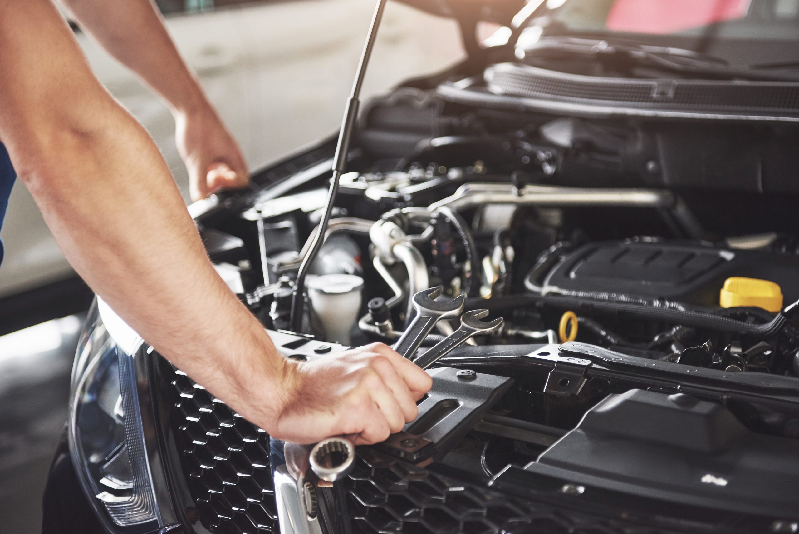close up hands unrecognizable mechanic doing car service maintenance